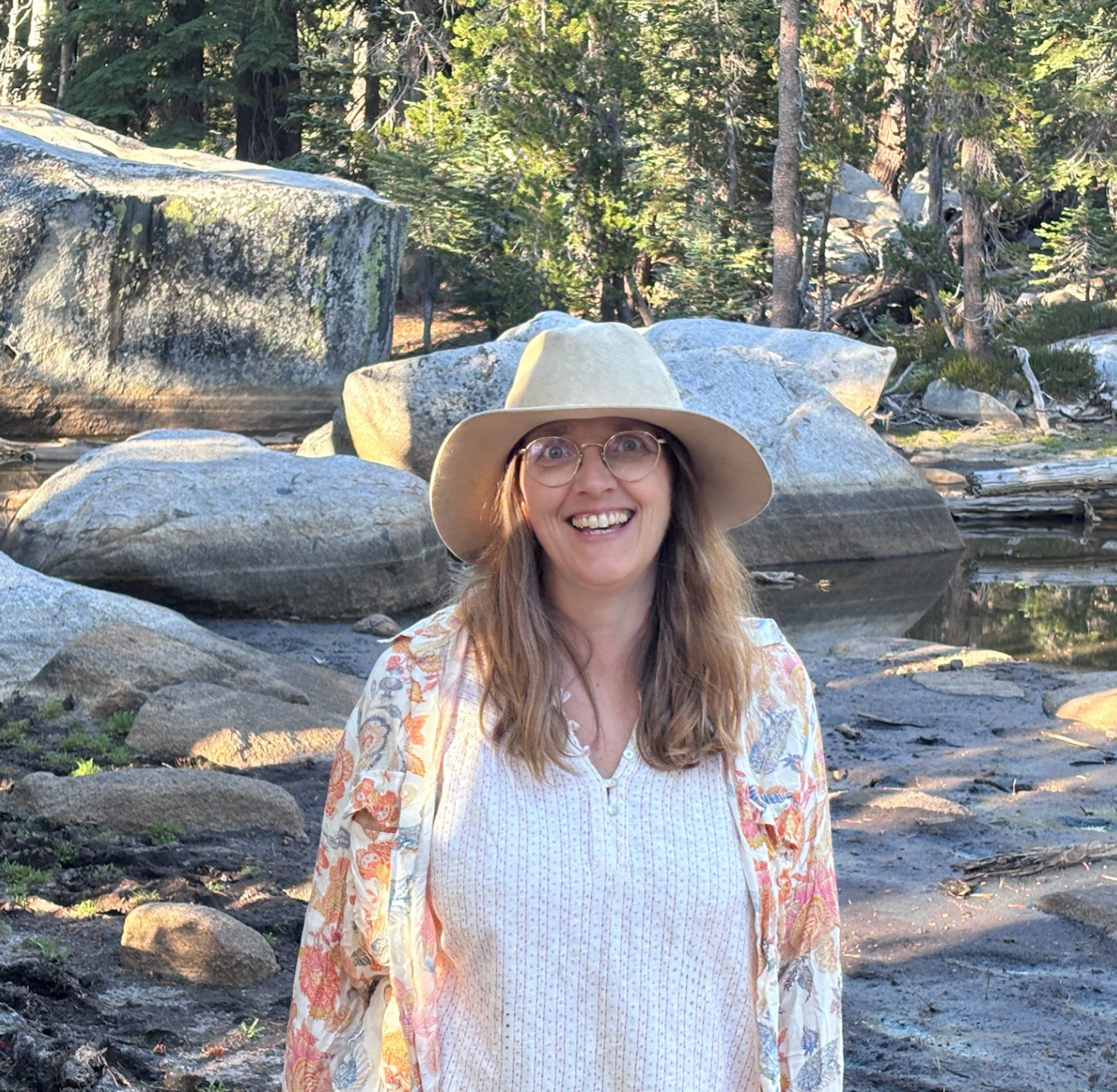 Light skinned woman with rocky, outdoor mountainous backdrop